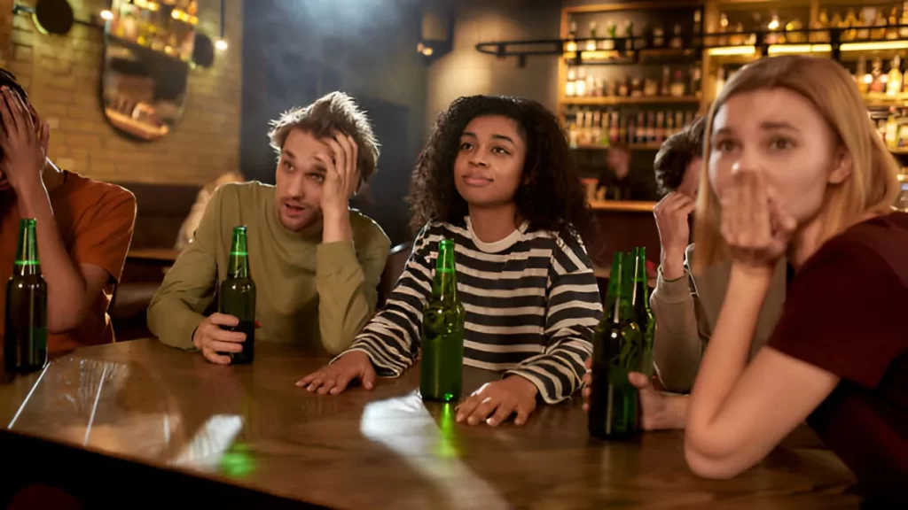 Sober man looking confused while interacting with a drunk girl at a party